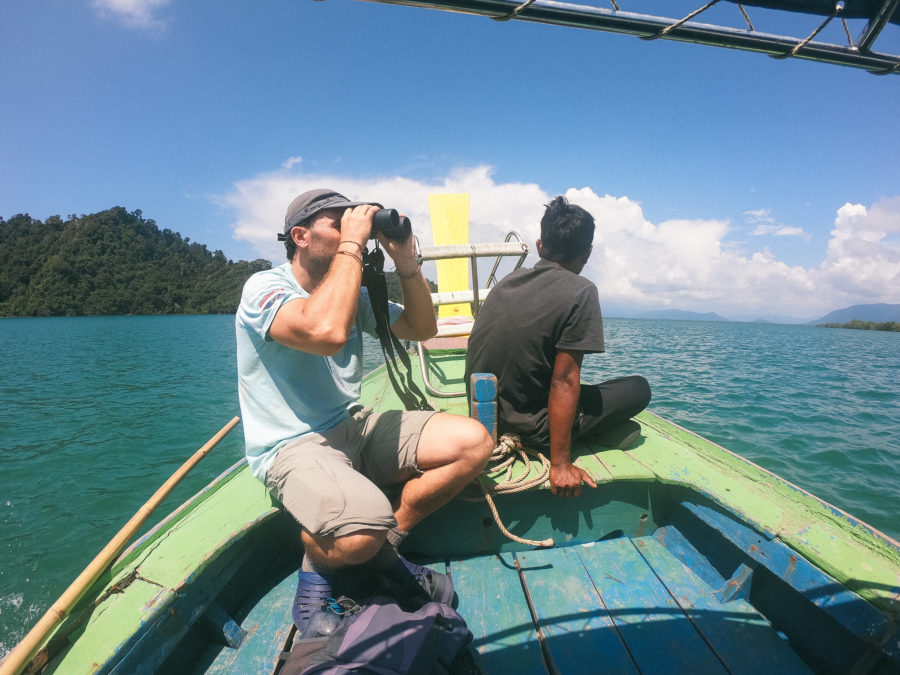 Photo of two volunteers wildlife watching from the bow of a small boat