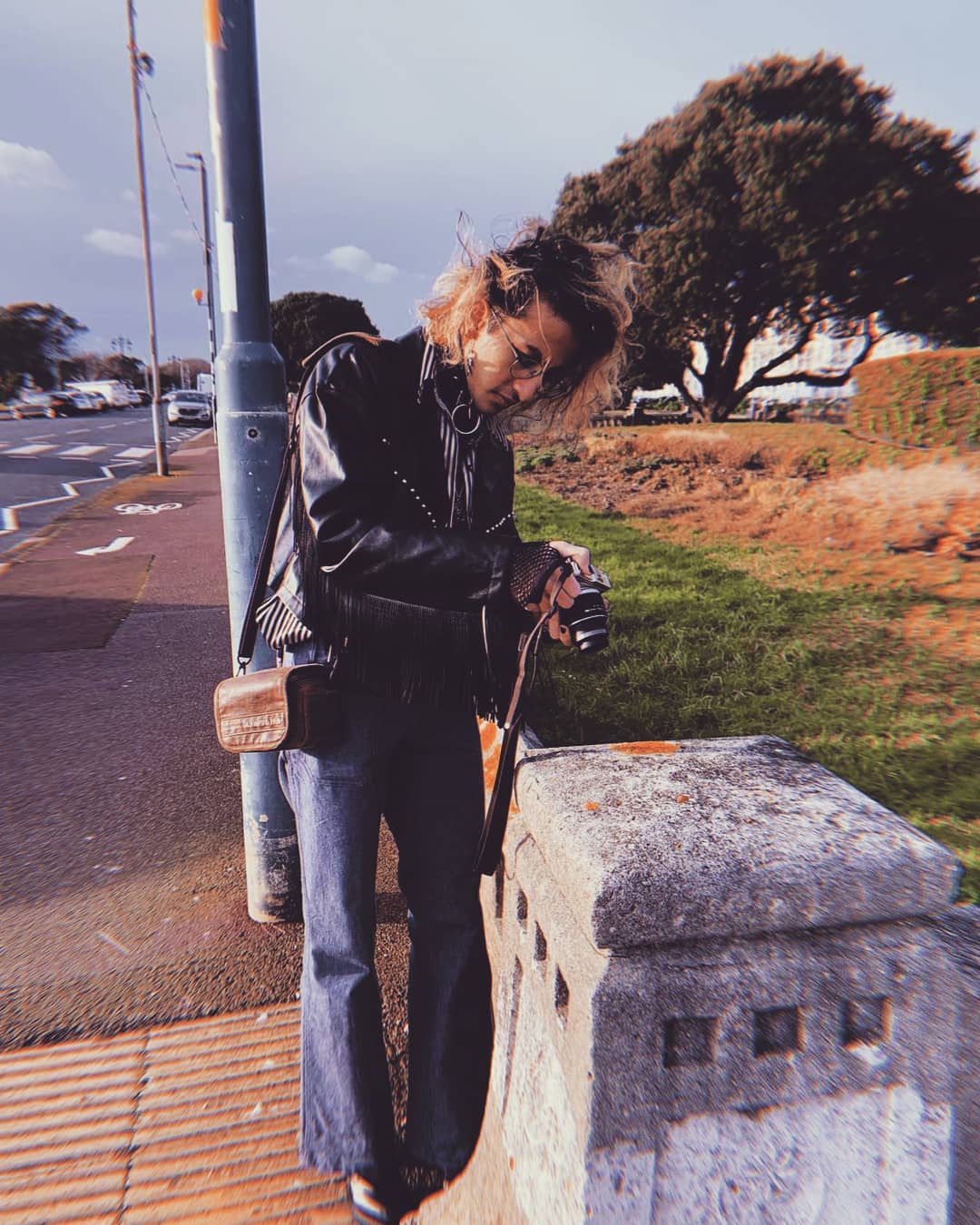 Dawood Qureshi photographing lichens on a stone wall in an urban environment.