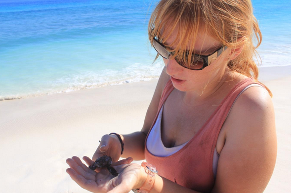 Kat Machin with a Hawksbill Turtle hatchling on Aride Island (photo: Kat Machin).