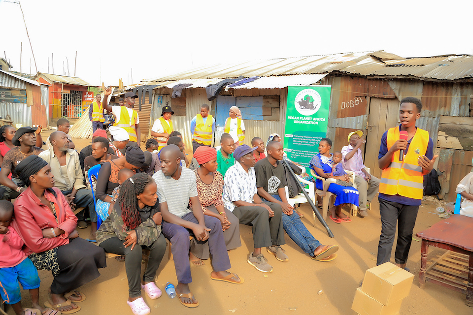 Julius hosting a community workshop with adults, engaging participants in discussions about animal rights, plant-based living, and environmental conservation as part of Vegan Planet Africa's outreach efforts.