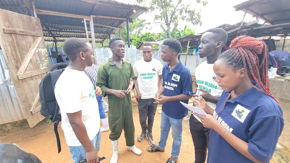 Julius engaging in a conversation with a local farmer during a community outreach event, discussing animal welfare and promoting sustainable farming practices.