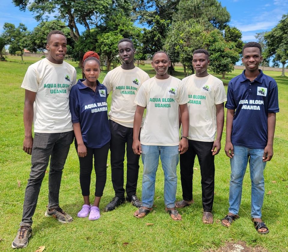 Julius Kirumira standing proudly with members of the Aqua Bloom Project.