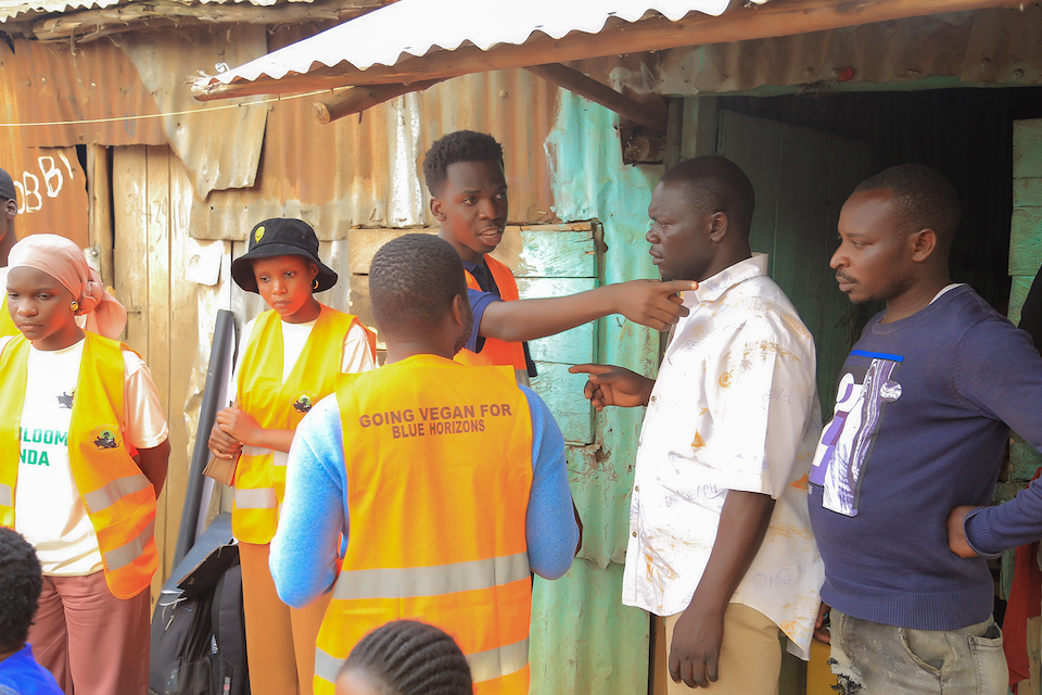 Julius engaging with local residents during a community outreach event for Vegan Planet Africa.