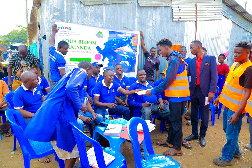 Julius leading a community campaign for the Aqua Bloom Uganda Project, engaging local men in environmental conservation efforts to protect marine life.