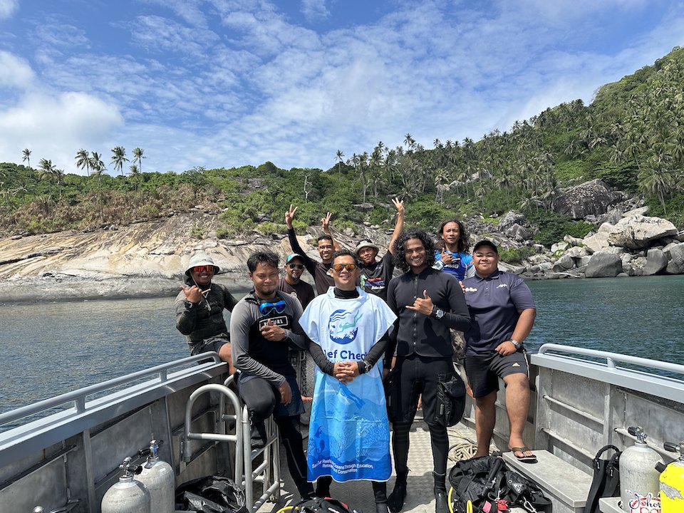 Nazirul with a group of divers on a boat.