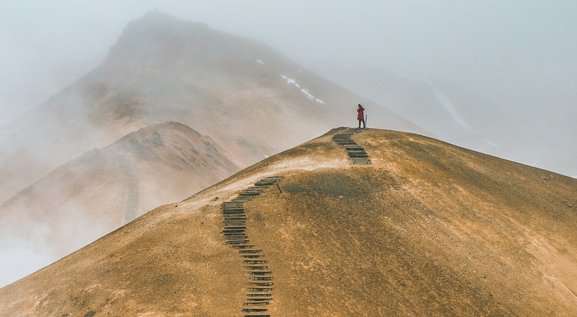 A person standing at the top of a bare mountain. Unlike professionals in other sectors, like international development and humanitarian aid, most conservationists have to chart their own paths to working abroad in conservation.