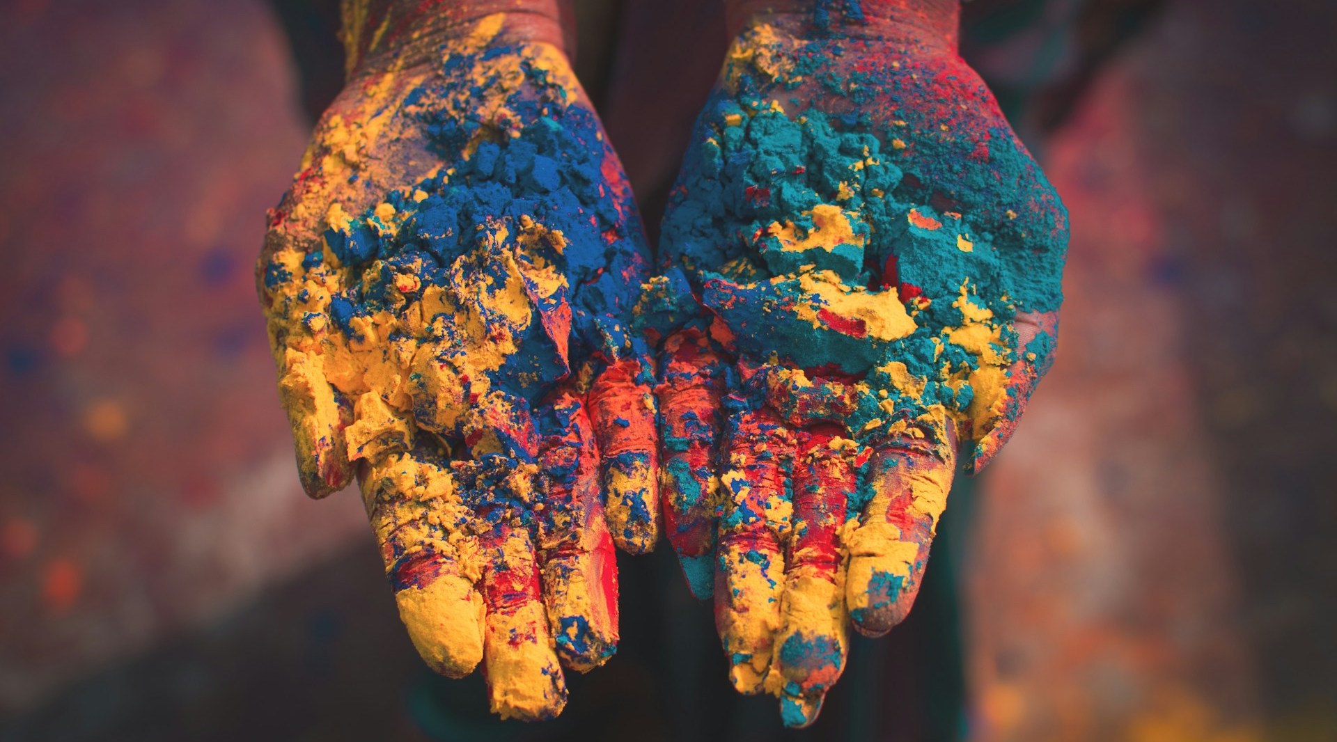 A pair of hands, palms up, covered in brightly-coloured paint. If you choose to work abroad in conservation, cross-cultural awareness and skills can greatly enrich your experience.