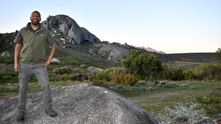 A male nature conservationist standing in the mountains.
