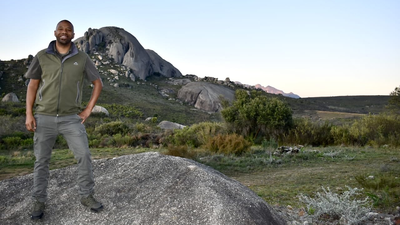 A male nature conservationist standing in the mountains.