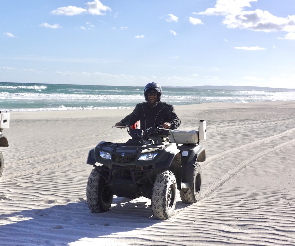 A male nature conservationist on a vehicle at the beach.