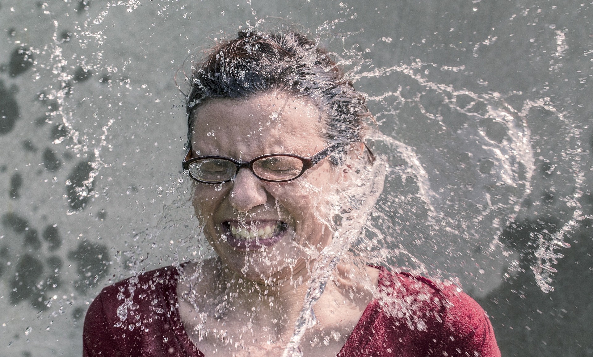 A woman wearing glasses being splashed in the face with water. If you work abroad in conservation and return home, reverse culture shock can hit you when you aren't expecting it.