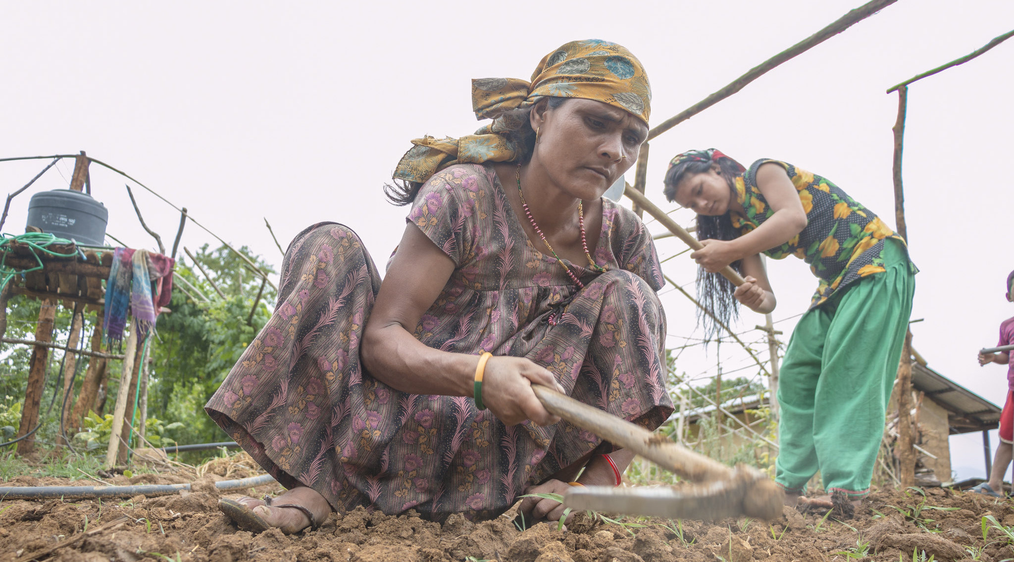 A woman tending the soil to grow fresh vegetables. Many community-based conservation careers focus on promoting both sustainable livelihoods and biodiversity conservation.