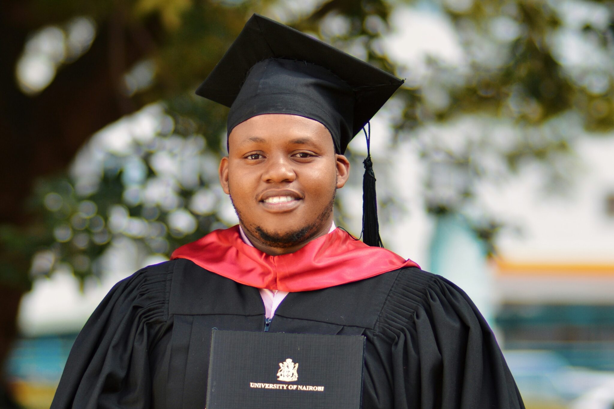 A young African man wearing graduation gown and cap, holding a diploma and smiling. Not all community-based conservation careers require a degree, but there are many great community-based conservation training programmes available.